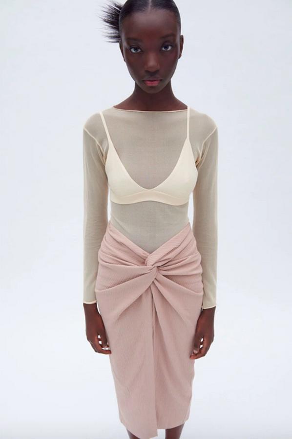 En rosa lavado, con tiro alto y diseño midi con detalle de nudo y abertura en delantero, esta falda de Zara que cuesta 25,95 euros y tiene cierre de cremallera oculta en costura en la espalda cuesta 25,95 euros y está disponible en las tallas S y M.