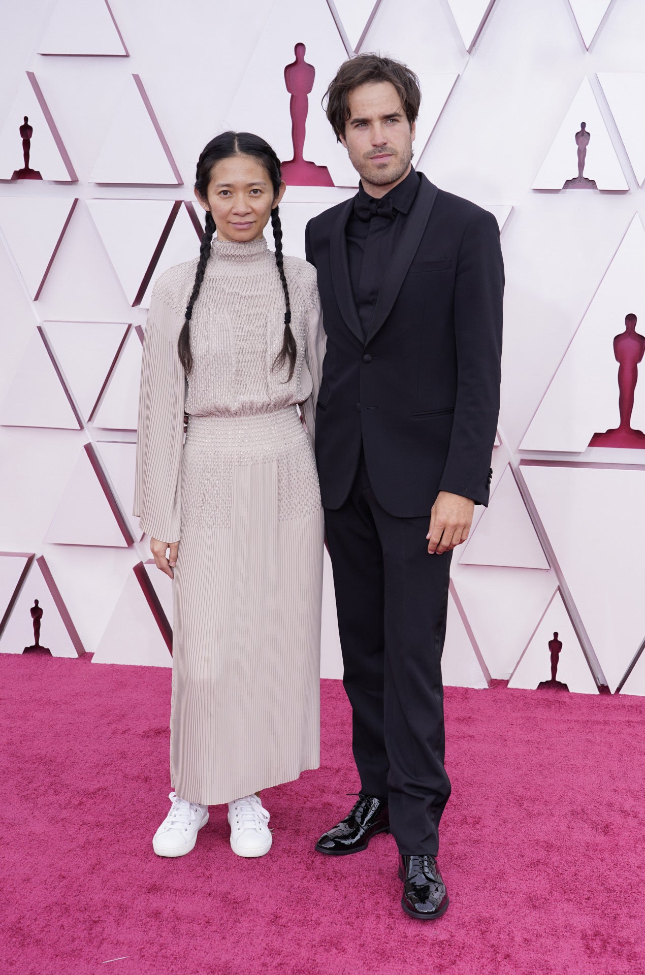 Chloé Zhao, con vestido de Hermès y con zapatillas blancas.