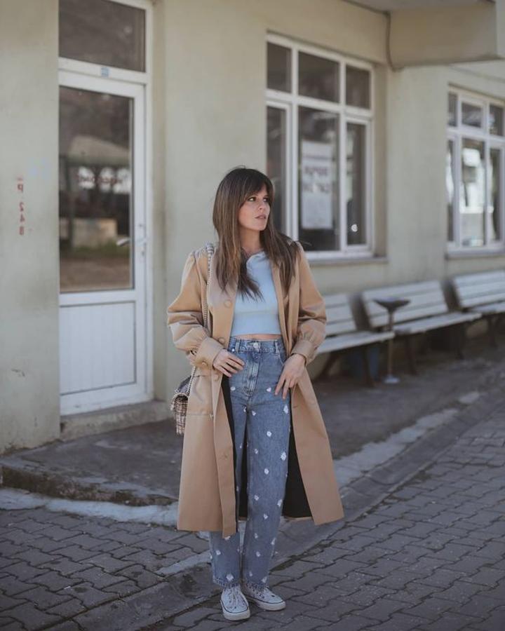 Trench en color arena + vaqueros con margaritas + zapatillas blancas