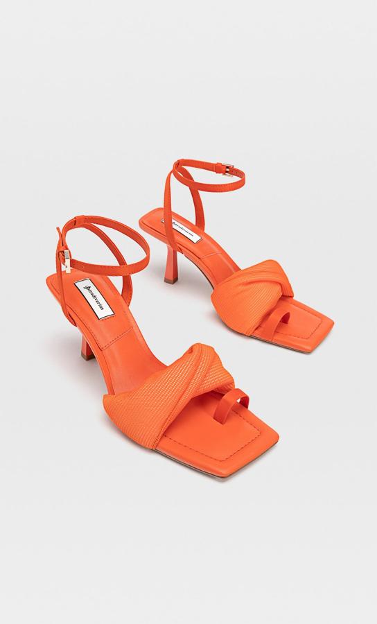 En color naranja, estas sandalias de tacón con altura de 7 centímetros y detalle de posición para el dedo tienen un precio de 29,99 euros.