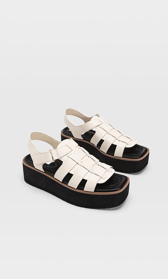 Estas sandalias planas estilo cangrejeras en color crudo cuentan con suela a contraste de color negro y tienen un precio de 35,99 euros.