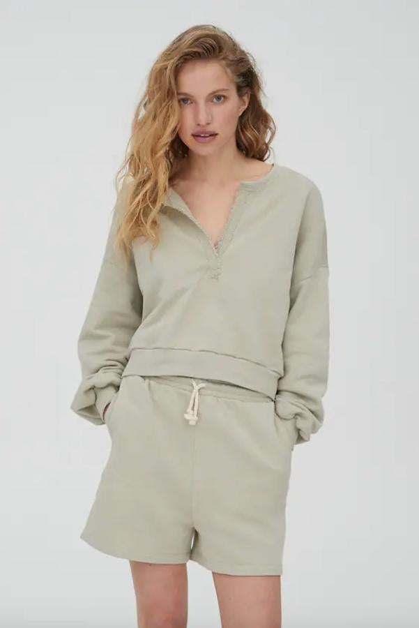 Con cuello panadero, mangas largas y acabados en rib, esta sudadera cropped de Pull&Bear en caqui cuesta 19,99 euros y está disponible en las tallas S, M y L.