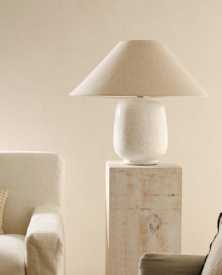 Con una altura de 54,6 centímetros y un ancho de 60, esta lámpara con base de cerámica con efecto craquelado y pantalla cónica de lino tiene un precio de 99,99 euros.