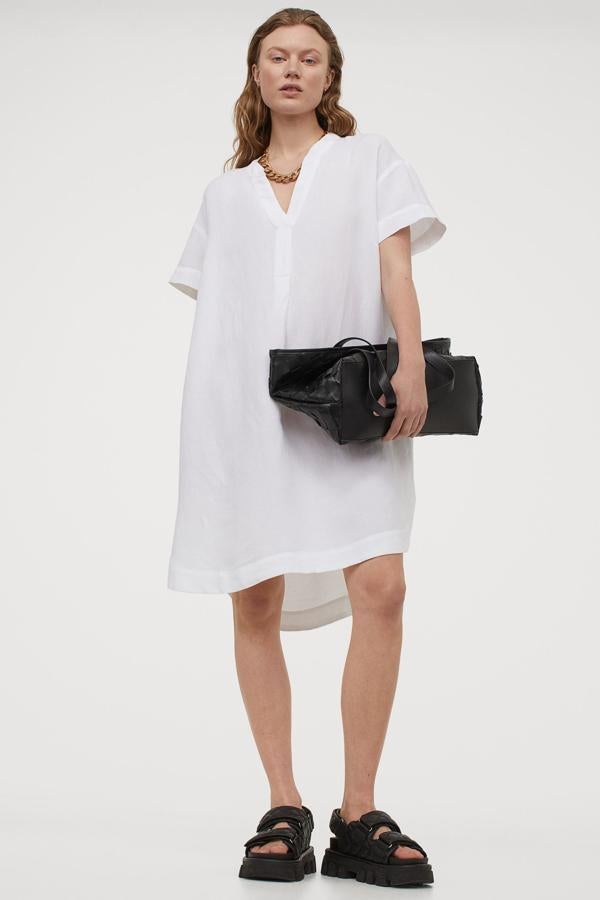Este vestido blanco corto con escote de pico y cuello elevado corto es de H&M, con corte recto, diseño de hombros caídos, mangas cortas y bajo redondeado asimétrico. Tiene un precio de 19,99 euros y está disponible entre las tallas XS y XXL.