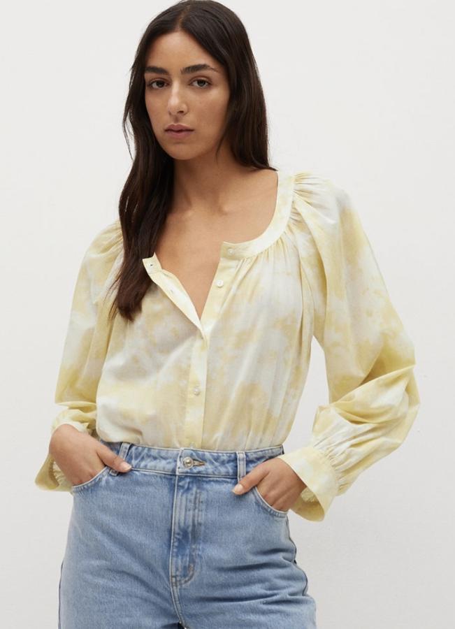 Con estampado de color amarillo, esta camisa de algodón en tejido semitransparente cuenta con cuello redondo, manga larga abullonada y cierre de botones. Tiene un precio de 29,99 euros.