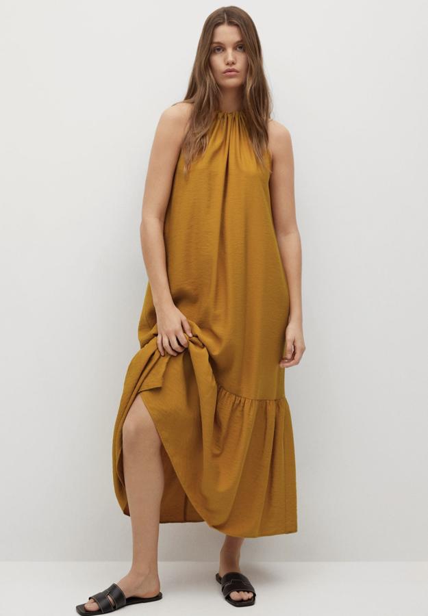 En tejido fluido, este vestido maxi con diseño acampanado y corte midi está disponible en naranja o en crudo. Con escote halter, tiene un precio de 39,99 euros.