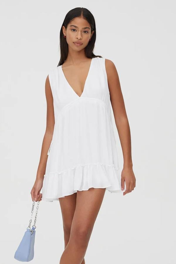 En color blanco, este vestido mini de bambula con escote de pico y detalle de volantes tiene un precio de 25,99 euros.