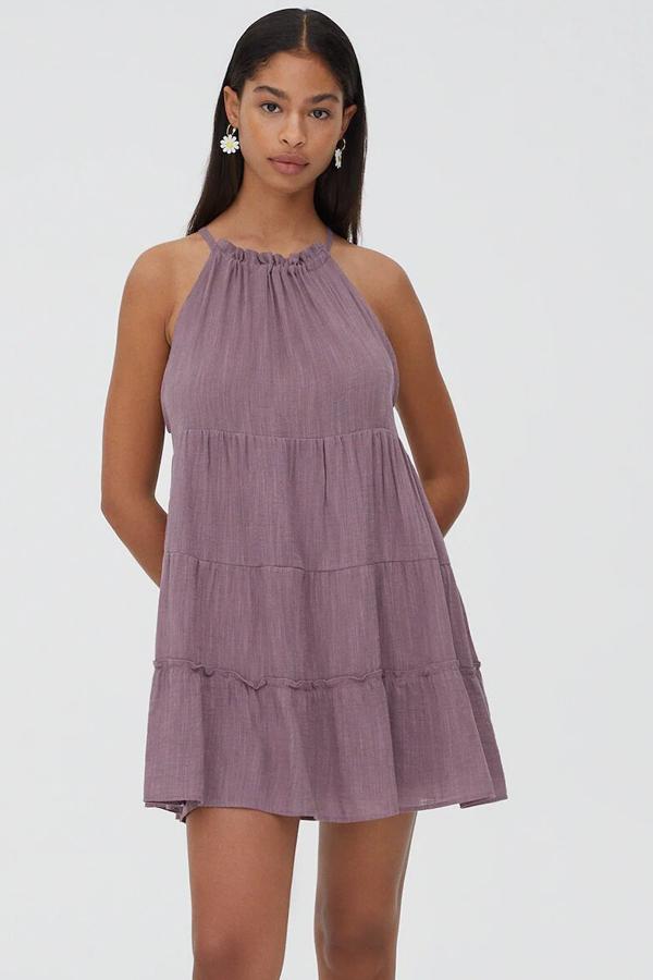 Disponible en lila o en crudo, este mini vestido con escote halter, silueta fluida y diseño de paneles tiene un precio de 22,99 euros.