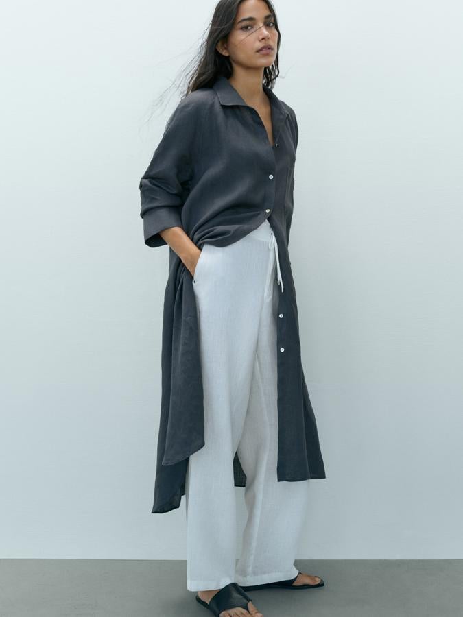 En un bonito color petróleo, que va a quedar perfecto con un pantalón blanco, este blusón confeccionado al 100% en lino europeo viene con cuello clásico, bajo con aberturas laterales y bolsillo de plastrón en la pechera. Con cierre de botones frontal y puños abotonados, podemos encontrarlo entre las tallas 34 y 42 por 59,95 euros.