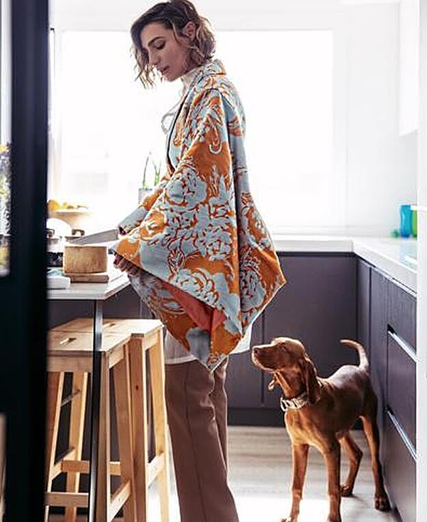 Eugenia Osborne en la cocina de su casa junto a su perro.