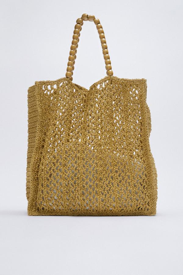 Bolso grande estilo "shopper" con calados y asas de bolitas de maderas de Zara (29,99e uros)