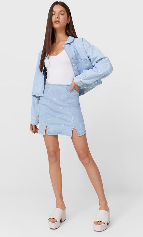 En color azul con bordados de margaritas, este conjunto cuenta con cazadora (35,99 euros) con puños abotonados y bolsillos en el pecho y falda (19,99) denim mini a juego con aberturas en el bajo.