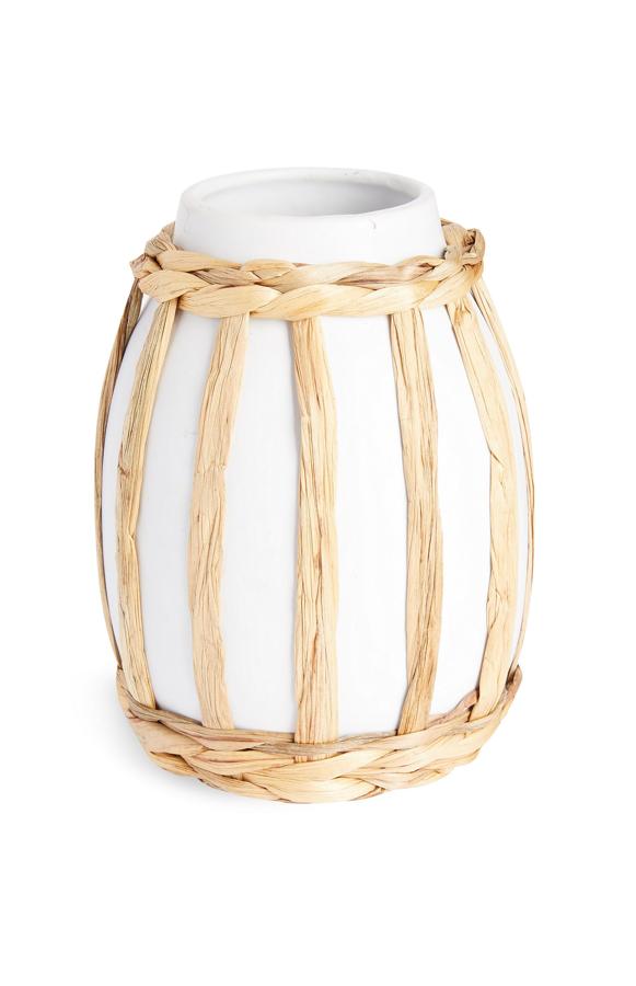 Este jarrón de cerámica en color blanco con detalle en ratán de color natural tiene un precio de 6 euros.
