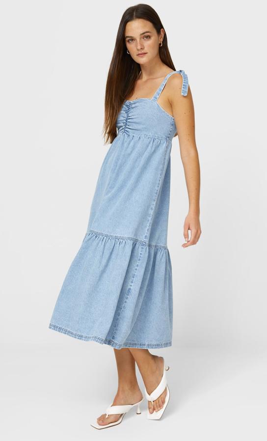 Este vestido largo denim con escote recto y elástico en el pecho cuenta con tirantes ajustables con lazada y bajo acabado en volantes. Tiene un precio de 29,99 euros.