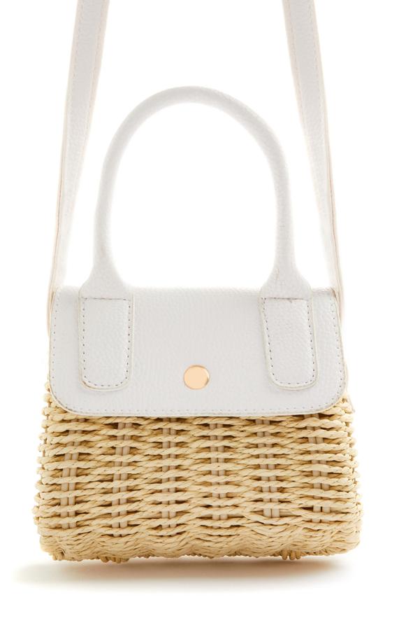 Este bolso mini de paja con bandolera en color blanco tiene un precio de 10 euros. También está disponible en azul celeste.