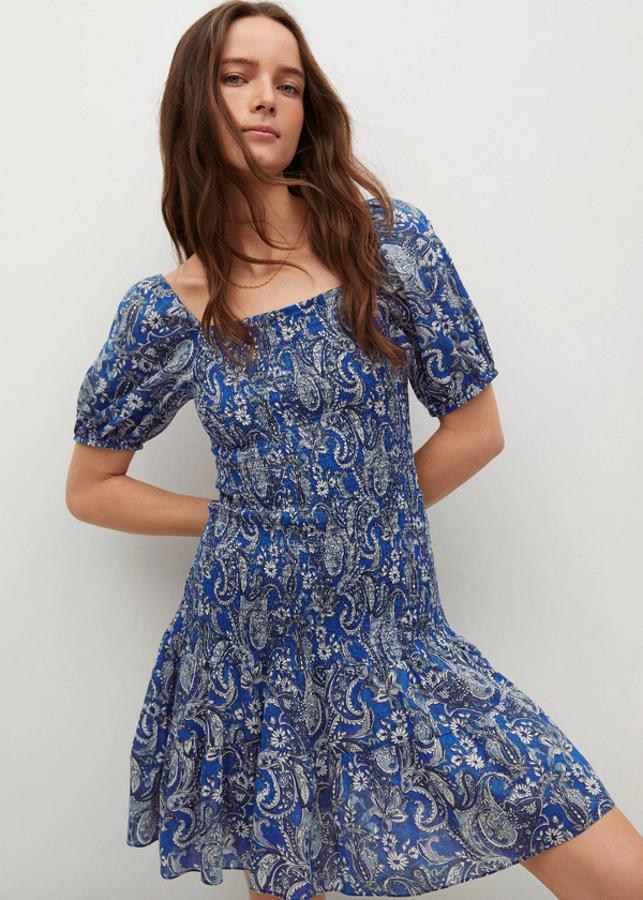 Estampado paisley en azul oscuro para este vestido de Mango con fruncido en la parte superior, diseño acampanado y entallado y escote recto. Con mangas cortas abullonadas y panel tipo nido de abeja, viene con volante en el bajo y podemos encontrarlo entre las tallas XS y XL por 29,99 euros.