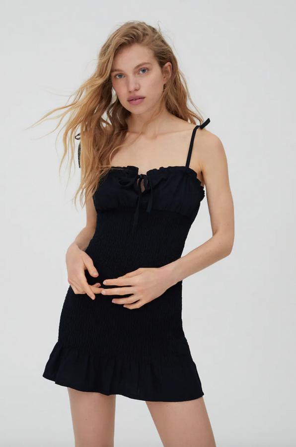 Con cuerpo en tejido nido de abeja, escote y tirantes con lazada y silueta ajustada, este vestido negro de Pull&Bear está disponible entre las tallas XS y L y cuesta 22,99 euros.