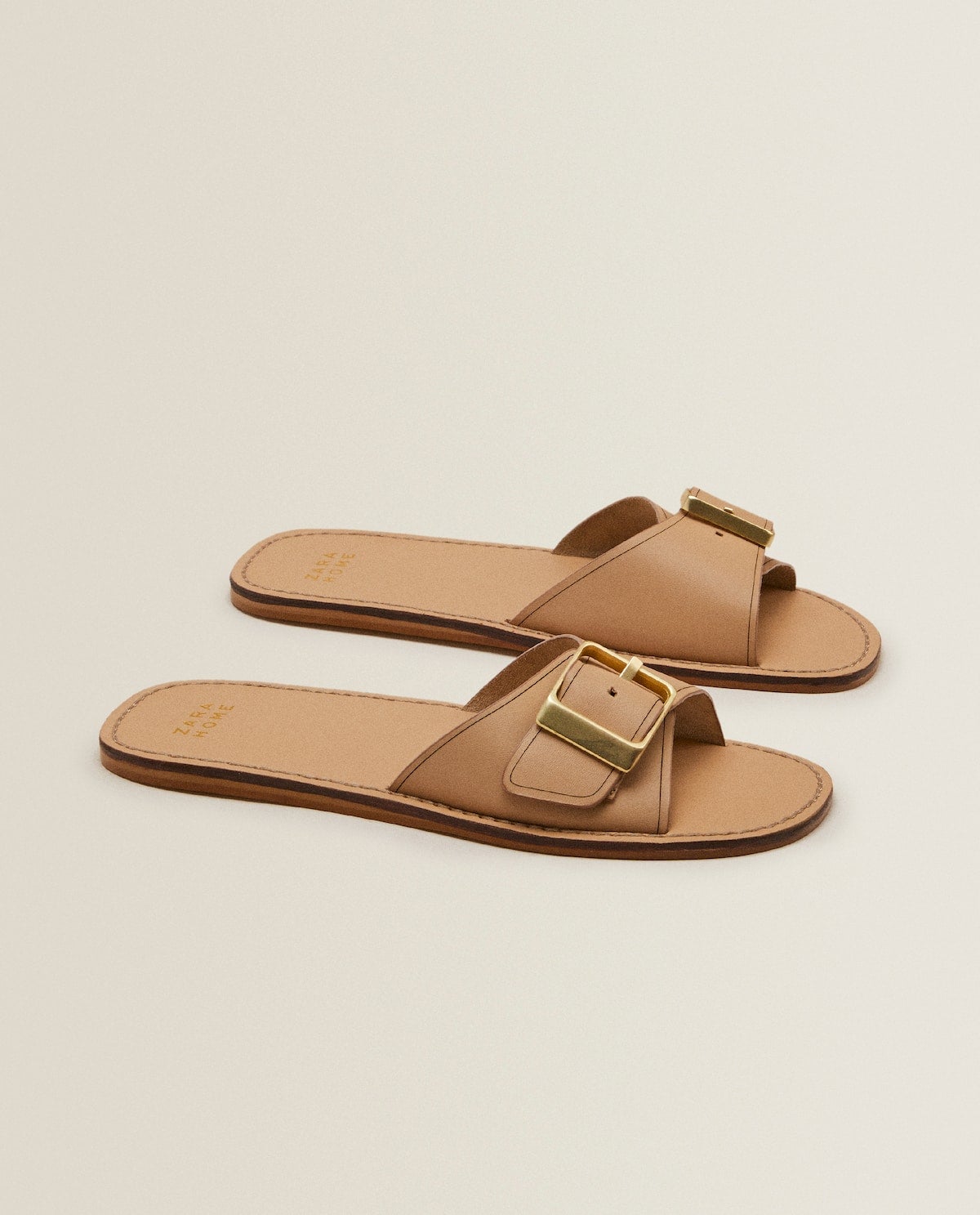 Sandalias planas tipo pala con tira y hebilla dorada. (29,99 euros).