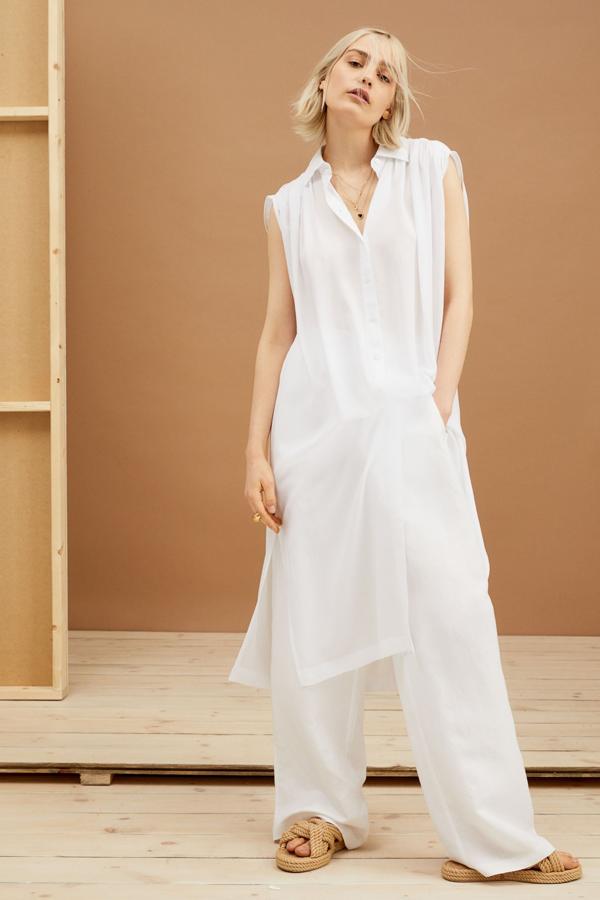 Este vestido camisero de color blanco cuenta con hombros fruncidos, sisas amplias y aberturas laterales. Tiene un precio de 29,99 euros.