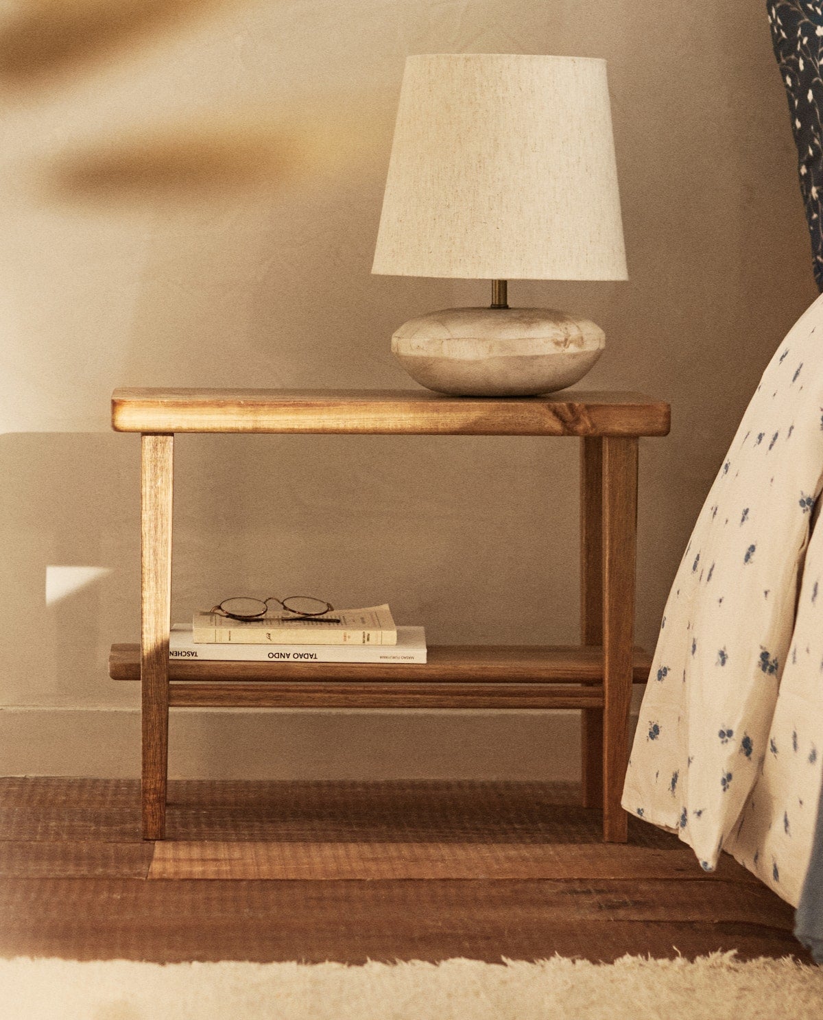 Banco de mandera de acacia de Zara Home, ideal para usar en el dormitorio como mesilla de noche y disfrutar de su elegancia y su funcionalidad. (79,99 euros).