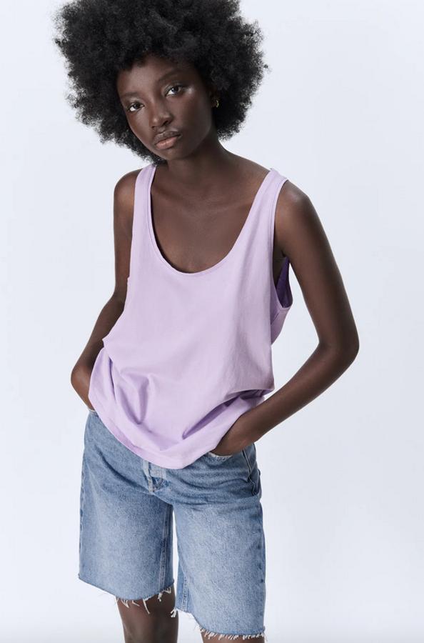 Escote redondo y manga sisa con tirantes para esta camiseta confeccionada con al menos un 50% de algodón orgánico que podemos encontrar en negro, blanco, lila y visón por 7,95 euros entre las tallas XS y XL, aunque algunas se han agotado.