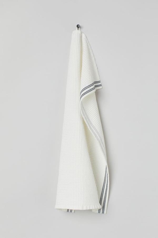 Las toallas hay que cambiarlas de vez en cuando. Aprovecha el verano y renueva las toallas del baño. Nuestra favorita: esta toalla de mano de H&M home (5,99 euros) en blanco y con dos rayas de color azul.