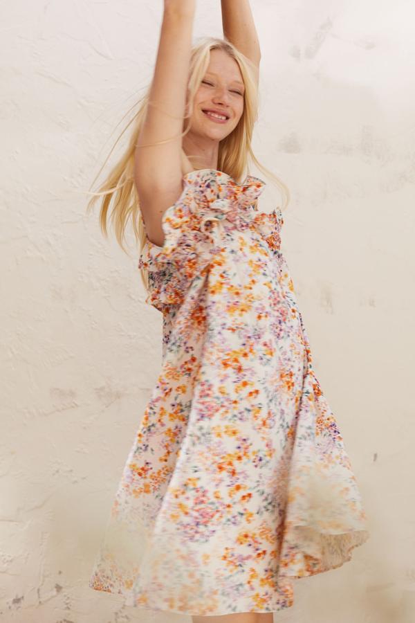 Este mini vestido de estampado floral (también disponible en blanco) con volante en el escote cuesta 24.99 euros en H&M.