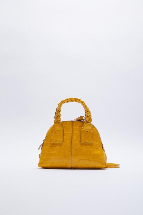 Bolso con asa corta trenzada en color mostaza de Zara (9,99 euros)