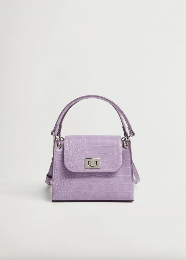 De tamaño pequeño y diseño rígido, este bolso de Mango con dos asas cortas y asa larga desmontable viene en formato solapa con cierre metálico de solapa. Cuesta 25,99 euros.