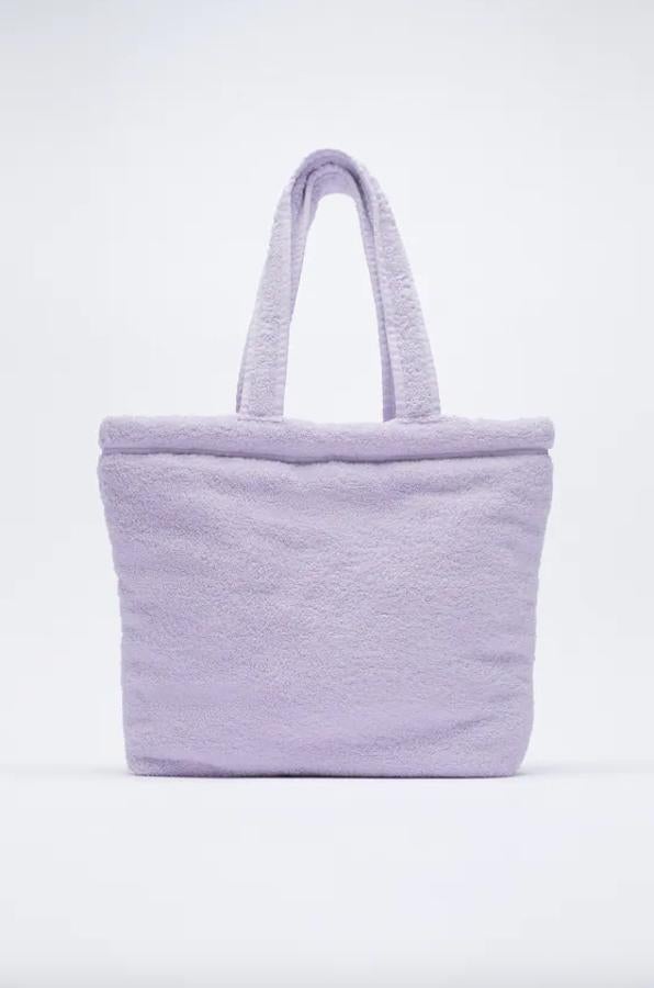 En formato maxi shopper y con cuerpo en efecto toalla, este bolso de Zara confeccionado al 50% en algodón orgánico, viene con asas de hombro e interior forrado. Con cierre de atado, podemos encontrarlo por 19,95 euros.