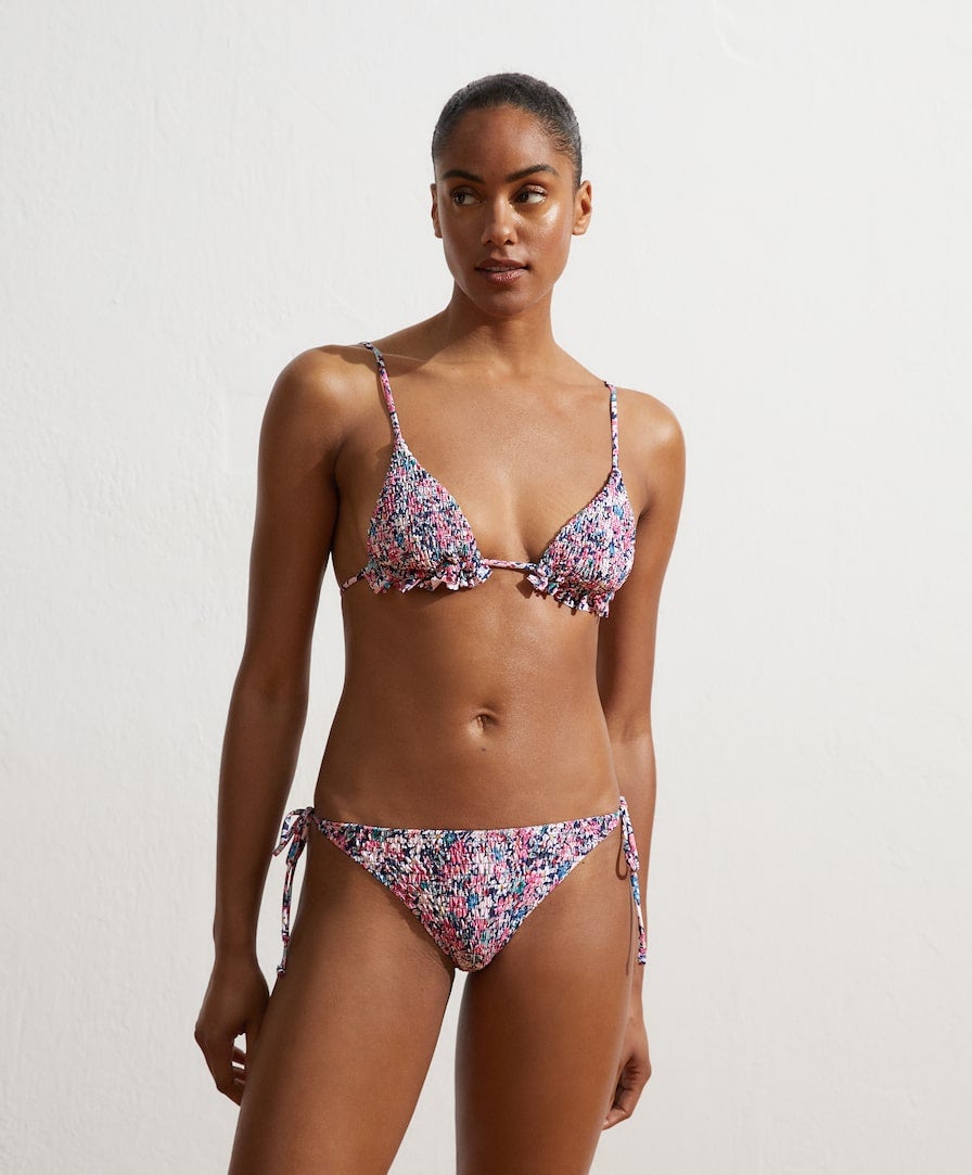 Bikini triangular sin aros de Oysho con estampado de flores, tejido fruncido y volantes (17,99 euros) más braguita brasileña a juego (12,99 euros).