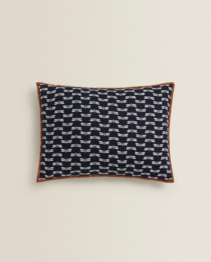 Los estampados de libélula son tendencia. Añade un plus de moda al sofá, o a la butaca que está en la zona de lectura. Se vende esta funda de cojín (19,99 euros) en Zara Home.