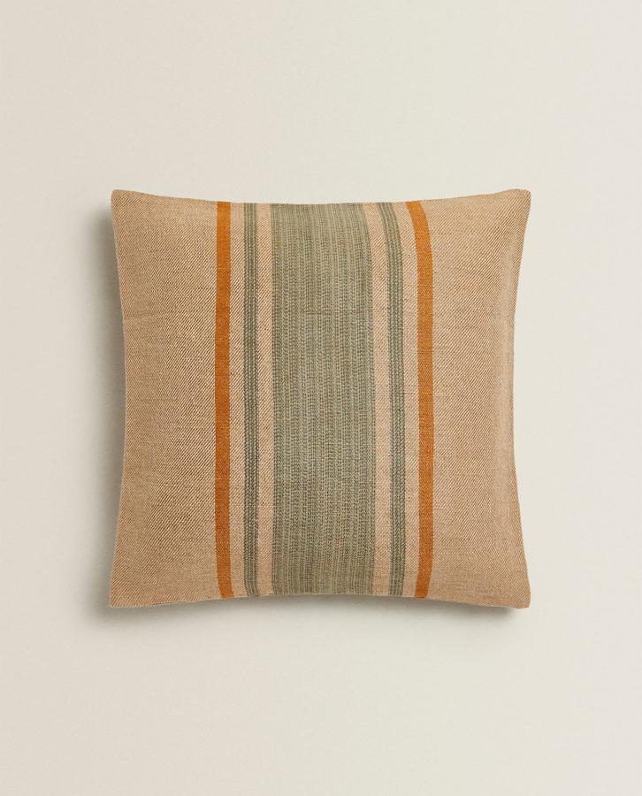 Si eres amante del estilo rústico y natural, entonces necesitas añadir una funda de cojín con estampado de rayas como esta. Está disponible en Zara Home por 29,99 euros.