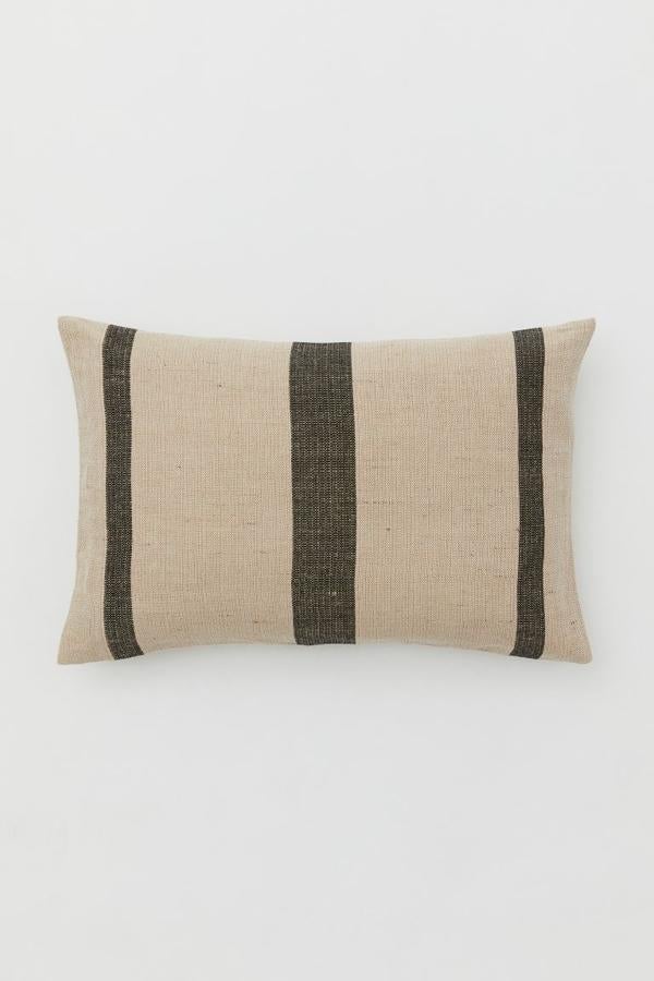 Con estampado de rayas, y tejido de lino, esta funda de cojín de la nueva colección de exterior de H&M Home es ideal para darle un plus de frescura al salón. Cuesta 12,95 euros y tiene unas medidas de 40x60 centímetros.
