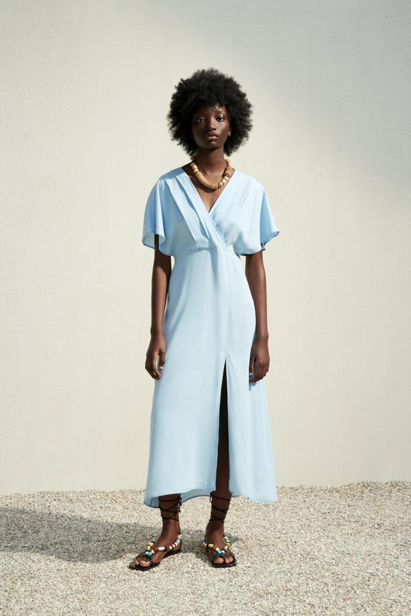 Este vestido midi azul bebé con escote cruzado y abertura en la falda, combinado con unos complementos potentes, puede convertirse en un look de invitada perfecta. ¿Su precio? 29.95 euros en Zara.