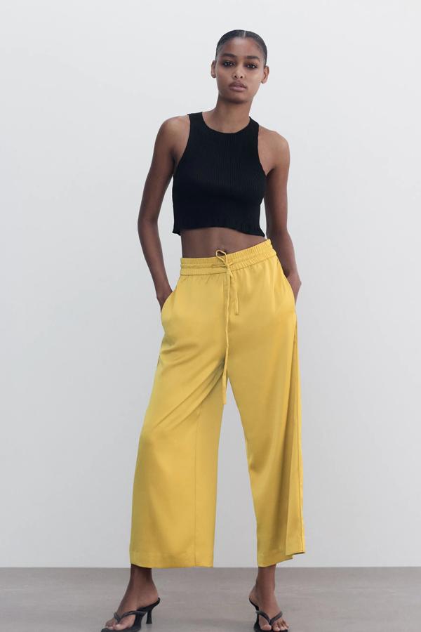 En color mostaza, aunque también disponible en negro, este pantalón fluido de tiro alto y con cintura elástica es de Zara y tiene un precio de 19,95 euros.