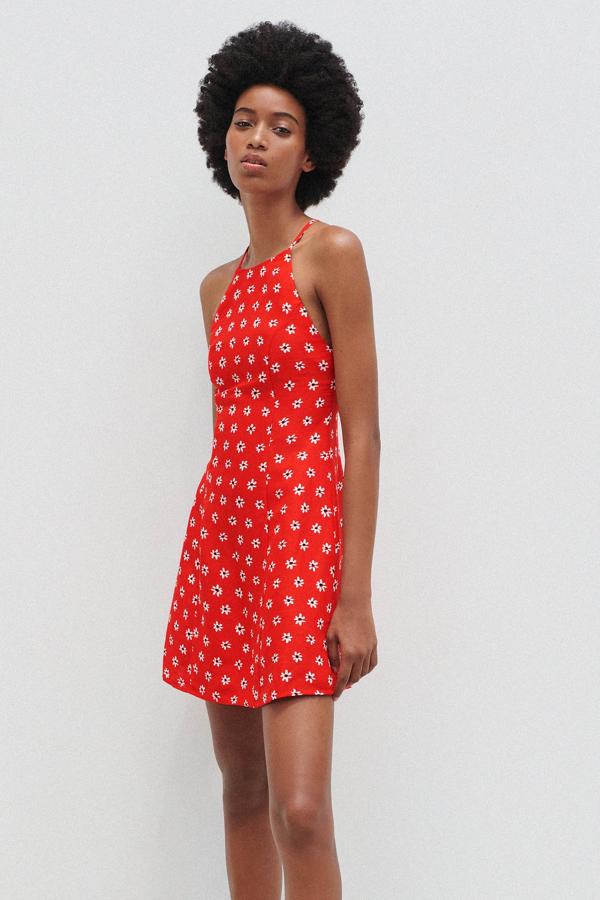 En color rojo y con flores blancas, este vestido mini de tirantes finos cruzados y escote halter cuenta con cierre en la espalda con cremallera oculta y tiene un precio de 25,95 euros. Es de Zara.