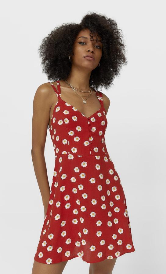 De color rojo y con estampado de margaritas, este vestido con escote de pico y tirantes cruzados en la espalda cuenta con botones en la parte delantera y tiene un precio de 19,99 euros.