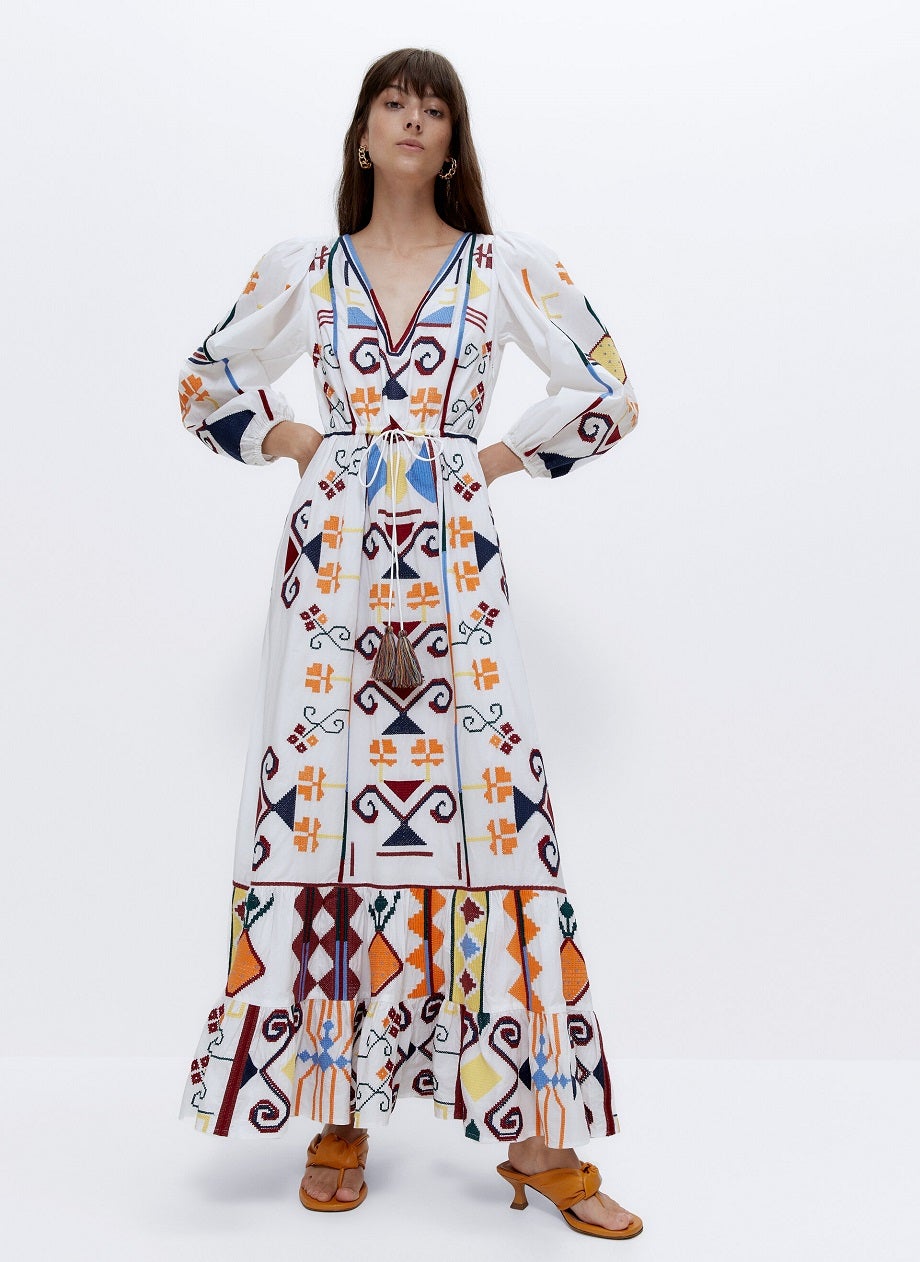 Escote en V, manga abullonada, bordados de hilo multicolor con diferentes formas y detalle de cinturón con pompones. Este vestido largo de Uterqüe es toda una joya de diseño que nos encantaría incluir en nuestro armario. ref. 0210/262.Precio: 159 euros.