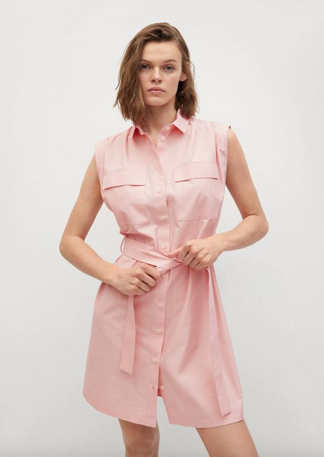 Este vestido camisero en rosa claro de Mango está confeccionado en tejido popelín de algodón y es de diseño corto y recto. Con cuello clásico y sin mangas, tiene dos bolsillos delanteros de plastrón con solapa en la pechera y cinturón ajustable a tono. De cierre frontal de botones, podemos encontrarlo entre las tallas XS y XL por 29,99 euros.
