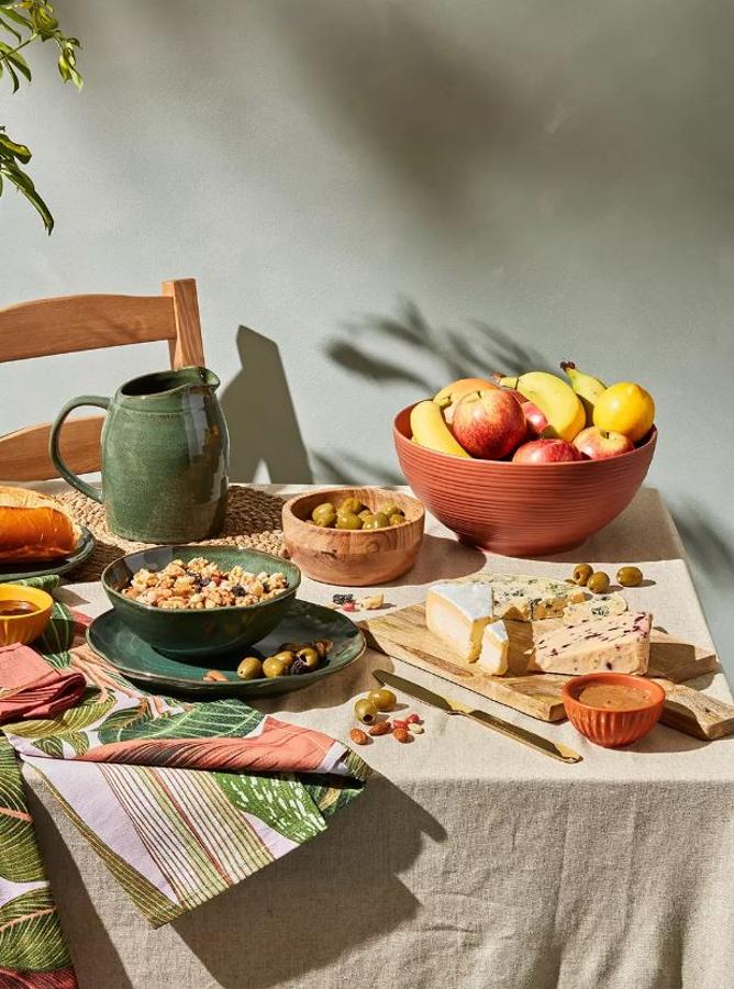 El menaje lleno de color y estampados alegres es el protagonista de nuestras mesas de verano, que se verán aún más apetecibles con estas piezas baratísimas de Primark Home: la jarra verde cuesta 6 euros, el plato verde y el bol a juego, 4 euros cada uno, el frutero de terracota 8 euros, los boless de madera 4 euros, el pack de 3 boles pequeños 3,50 euros, el conjunto de 2 manteles individuales de mimbre tejidos 5 euros y el mantel estampado 9 euros.