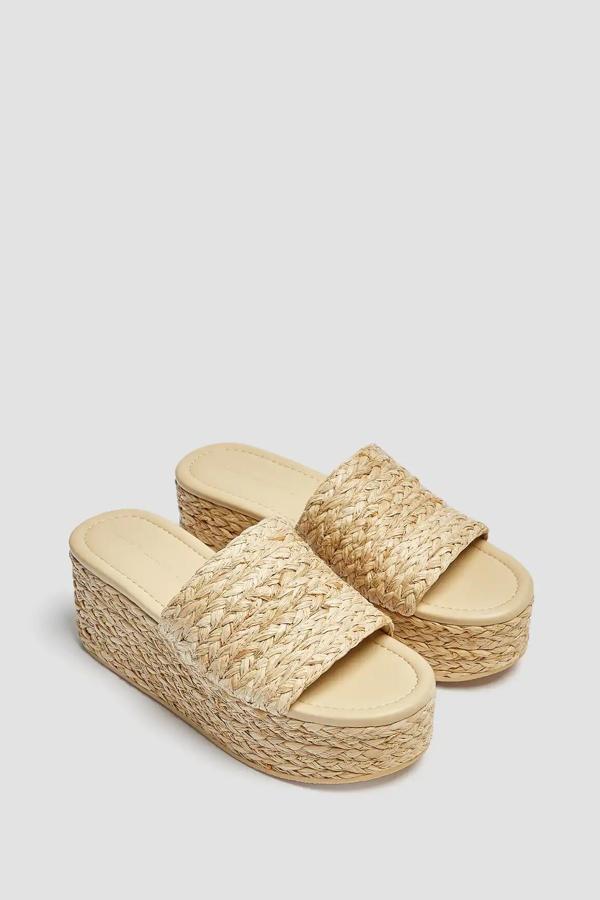 Esta cuña trenzada con tira ancha delantera en color natural tiene una altura de 7 centímetros y un precio de 29,99 euros.