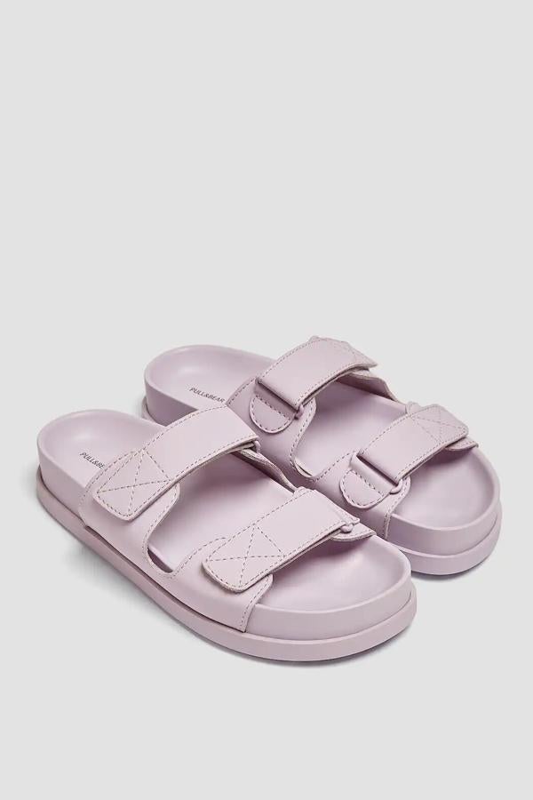 Disponible en color malva o caqui, esta sandalia plana con detalle de tiras en el corte y cierre adherente es súper cómoda y tiene un precio de 25,99 euros.