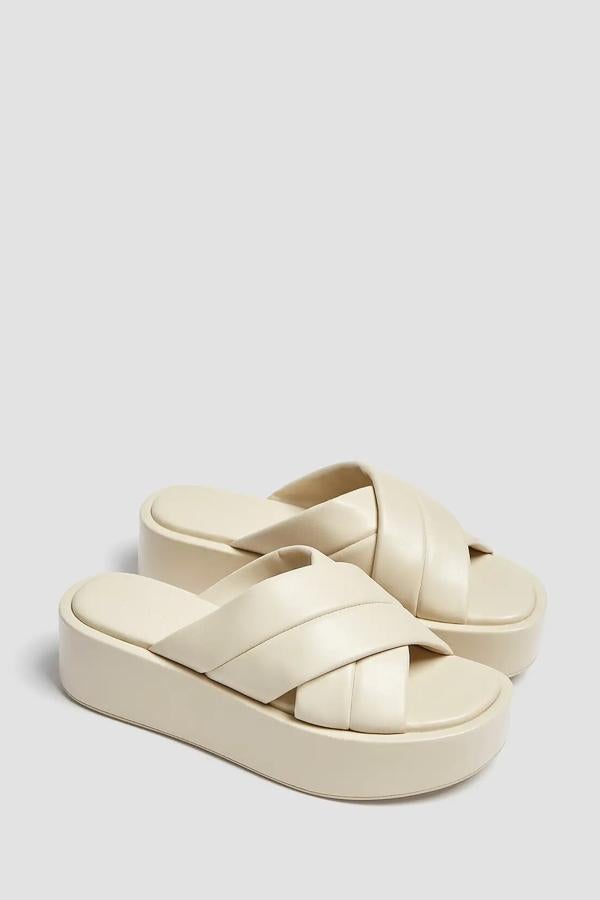 En color blanco roto, esta cuña con detalle de tiras cruzadas acolchadas tiene una altura de 5 centímetros y un precio de 29,99 euros.