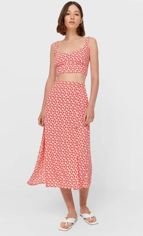 Con estampado de flores en color fucsia oscuro, este conjunto está formado por una falda midi (15,99 euros) con detalle de aberturas en el bajo y un top (12,99 euros) de tirantes.