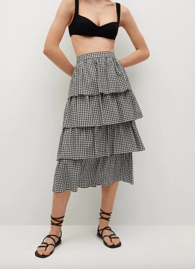 Mango también apuesta por el cuadro vichy en negro y blanco para esta falda de algodón de diseño midi acampanado con volantes y de cintura alta. Cuesta 39,99 euros y podemos encontrarla entre las tallas XS y XL.