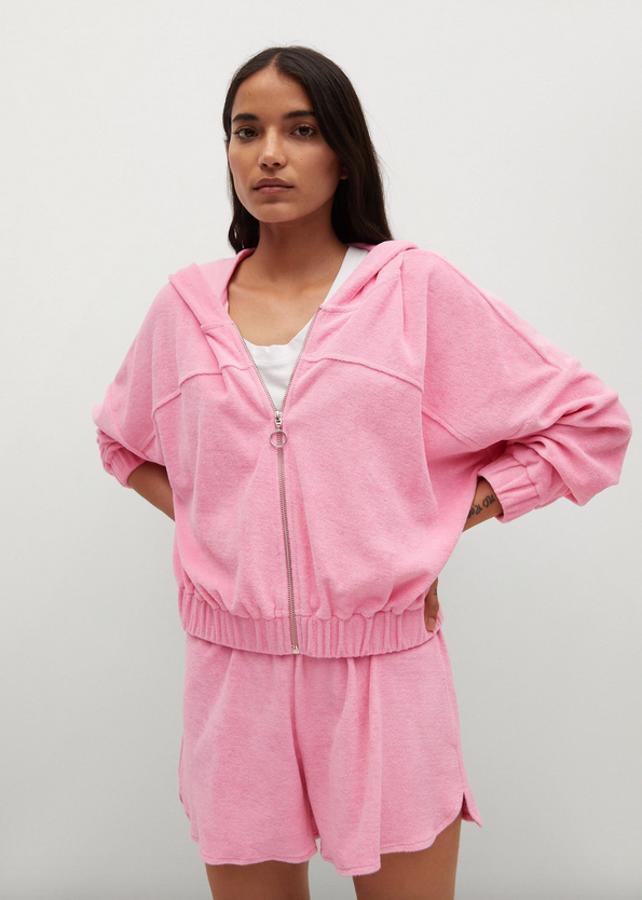 De diseño recto u manga larga, esta bonita sudadera en color rosa viene con costura de hombro caída, capucha y terminaciones elásticas en los puños y el bajo. Tiene cierre de cremallera con anilla, cuesta 29,99 euros y está disponible entre las tallas XS y XL.