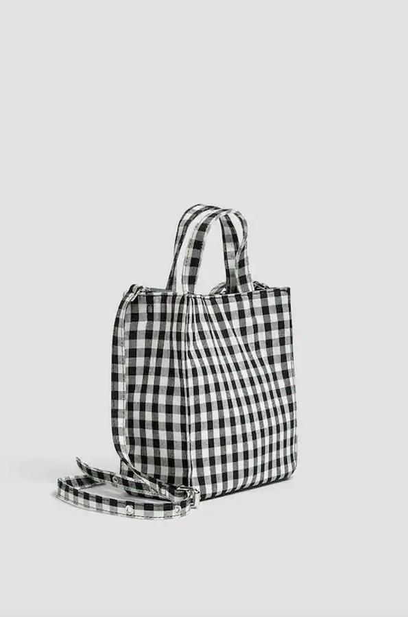 En formato bandolera con estampado de cuadro vichy en negro y blanco, este bolso con asas de mano y asa de hombro ajustable y extraíble que tiene cierre superior de imán ha pasado de 17,99 euros ha pasado a costar 12,99 euros.