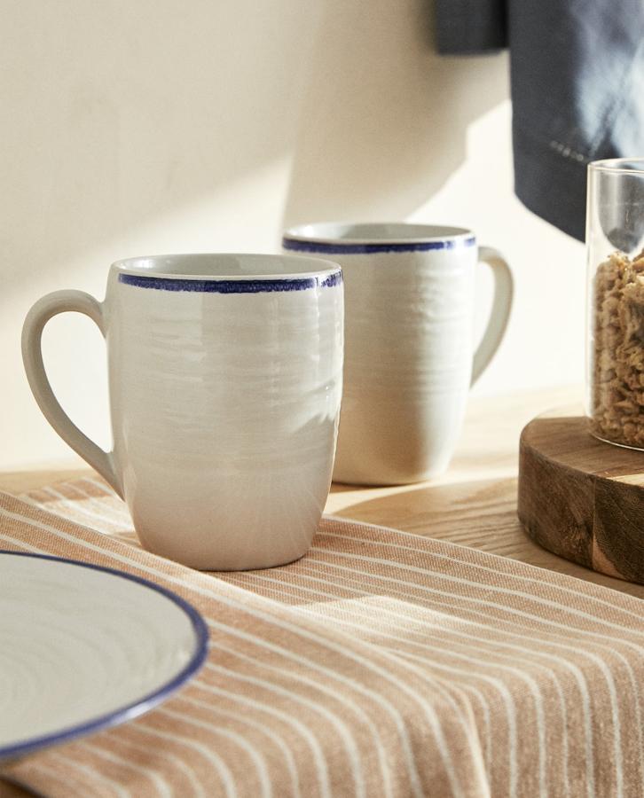 La mezcla de blanco y azul no debe faltar en una mesa de estilo marinero. Estas tazas de gres con relieve son de Zara Home, y cuestan 5,99 euros. Tienen capacidad para 330 ml.