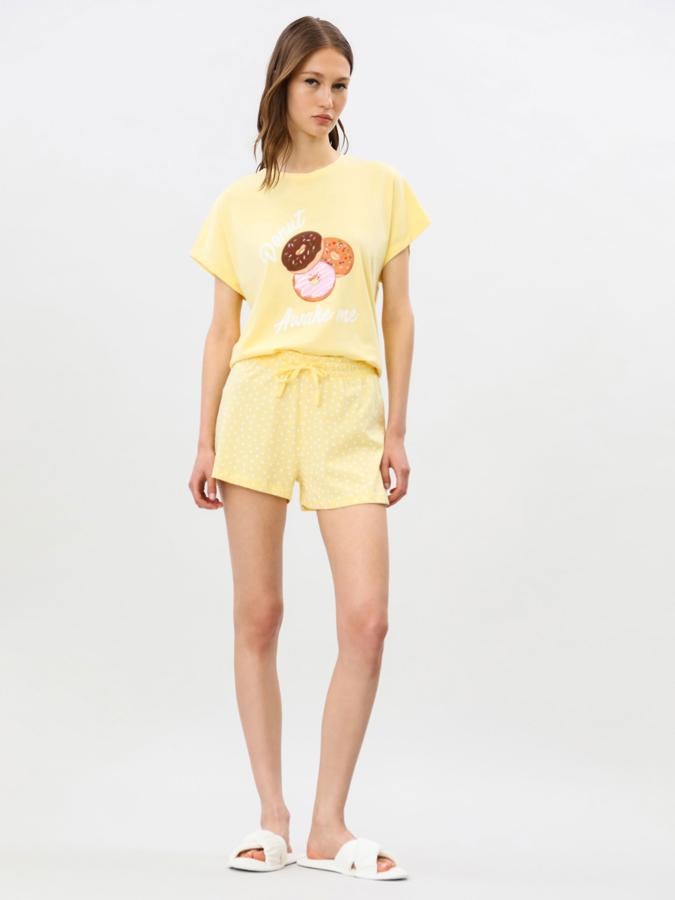 En color amarillo y con estampado de donuts, este pijama cuenta con camiseta de manga corta y pantalón de topos con lazo a la cintura. Tiene un precio de 7,99 euros.